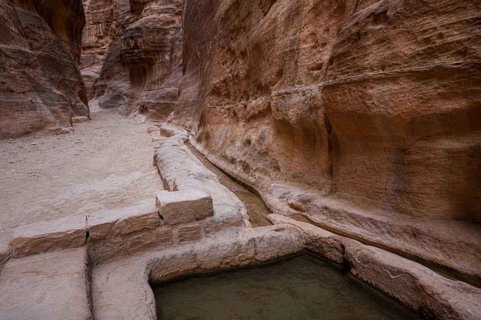 ペトラのシークに刻まれた古代の岩盤水路と貯水設備